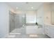 Spacious main bathroom with a soaking tub, glass shower, and ample vanity space at 609 Ramsours Mill Dr, Holly Springs, NC 27540