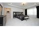 Elegant main bedroom with a tray ceiling, modern lighting, and sophisticated black and gray furnishings at 609 Ramsours Mill Dr, Holly Springs, NC 27540