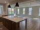 Modern kitchen with quartz countertops, a large center island, stainless steel appliances, and a farmhouse sink at 61 Black Walnut Dr # 188, Garner, NC 27529