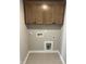 Functional laundry room with upper cabinets, tile flooring, and washer/dryer connections at 61 Black Walnut Dr # 188, Garner, NC 27529