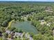 An aerial view showcasing a pond surrounded by lush trees and homes, offering a serene environment at 7601 Wellesley N Park, Raleigh, NC 27615