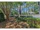 Green backyard featuring mature trees, a patio umbrella, and lush landscaping at 7601 Wellesley N Park, Raleigh, NC 27615