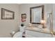 Elegant powder room featuring a decorative mirror, granite countertop, and stylish fixtures at 7601 Wellesley N Park, Raleigh, NC 27615