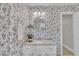 Bathroom featuring vanity with granite countertop, patterned wall paper, and round mirror at 7601 Wellesley N Park, Raleigh, NC 27615