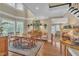 Spacious dining area featuring hardwood floors, a rug, large windows, and access to the living area at 7601 Wellesley N Park, Raleigh, NC 27615