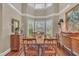 The dining room features hardwood floors, a rug, a chandelier, and natural light from bay windows at 7601 Wellesley N Park, Raleigh, NC 27615