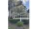 Exterior view with a beautiful dogwood tree, decorative fencing, and blue siding at 7601 Wellesley N Park, Raleigh, NC 27615