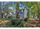 Rear exterior view of a blue sided home featuring an outdoor patio, mature trees and manicured lawn at 7601 Wellesley N Park, Raleigh, NC 27615