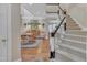 A foyer features hardwood floors, carpeted stairs with white spindles and a dining room at 7601 Wellesley N Park, Raleigh, NC 27615
