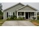Close up of an attractive single-story house with gray siding, a front porch, and a concrete driveway at 764 Grove Creek Ln, Raleigh, NC 27610