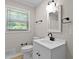 Well lit bathroom features a white sink, vanity and toilet next to a large window at 780 Indian Trail Village, Burlington, NC 27217