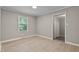Bright bedroom with neutral walls, wood-look flooring, and a view to the closet at 780 Indian Trail Village, Burlington, NC 27217