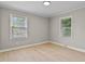 Well-lit bedroom with neutral walls, plank flooring, and large windows at 780 Indian Trail Village, Burlington, NC 27217
