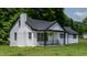 Charming exterior view of a one-story home with a covered porch and lush surrounding greenery at 780 Indian Trail Village, Burlington, NC 27217