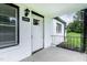 Inviting front porch with a white brick exterior and a decorative black metal railing at 780 Indian Trail Village, Burlington, NC 27217