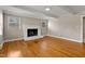 Cozy living room featuring a white painted brick fireplace and hardwood flooring at 780 Indian Trail Village, Burlington, NC 27217