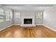 Charming living room with a white brick fireplace, hardwood floors and multiple windows at 780 Indian Trail Village, Burlington, NC 27217
