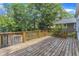 Wooden back deck and basketball area are surrounded by trees, with a unique treehouse visible behind the deck at 821 Onslow St, Durham, NC 27705
