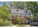 White two-story home with a wooden deck, lawn, a slide into a trampoline, and a basketball court at 821 Onslow St, Durham, NC 27705