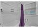 Clean white bathroom with subway tile, a purple shower curtain, and a built-in shelf at 821 Onslow St, Durham, NC 27705