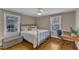 Comfortable bedroom with hardwood floors, a ceiling fan, and natural light streaming through the windows at 821 Onslow St, Durham, NC 27705