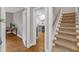 Hallway view showcasing hardwood floors, a staircase, and an inviting doorway to a cozy room at 821 Onslow St, Durham, NC 27705