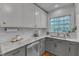 Bright kitchen featuring white cabinets, stainless steel appliances, marble countertops, and a window overlooking the yard at 821 Onslow St, Durham, NC 27705