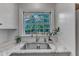 Close-up of a kitchen sink with marble countertops, white cabinets and stainless steel fixtures at 821 Onslow St, Durham, NC 27705