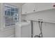 Functional laundry room featuring a washing machine, built-in cabinets, and a window for ample natural light at 821 Onslow St, Durham, NC 27705