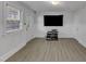 Bright living room with vinyl floors, neutral walls, and a large flatscreen TV at 821 Onslow St, Durham, NC 27705