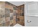Updated shower featuring stone tile, white trim and a storage caddy at 821 Onslow St, Durham, NC 27705