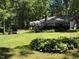 Expansive backyard featuring a manicured lawn, mulit-tiered deck, mature landscaping, and a built-in firepit at 8620 Glendale Dr, Apex, NC 27539