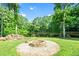 A cozy outdoor fire pit surrounded by lush greenery offers a relaxing space in nature at 8620 Glendale Dr, Apex, NC 27539