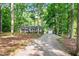 Charming home featuring a long gravel driveway, detached garage, and surrounded by lush trees at 8620 Glendale Dr, Apex, NC 27539