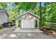 Detached garage with white door, potted plants, sitting adjacent to a deck with stairs at 8620 Glendale Dr, Apex, NC 27539