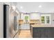 Well-lit kitchen boasts stainless appliances, white cabinets, and modern finishes at 8620 Glendale Dr, Apex, NC 27539