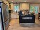 Eat-in kitchen with stainless steel appliances, granite countertops, custom cabinets and modern island at 8620 Glendale Dr, Apex, NC 27539