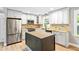 Modern kitchen with stainless steel appliances, island, white cabinets and tiled backsplash at 8620 Glendale Dr, Apex, NC 27539