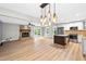 Spacious living area with a brick fireplace, wood floors, and an open kitchen at 8620 Glendale Dr, Apex, NC 27539