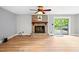 Cozy living room featuring a brick fireplace, ceiling fan and sliding glass doors at 8620 Glendale Dr, Apex, NC 27539