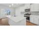 Bright kitchen featuring a quartz countertop island, stainless steel appliances, and a sliding glass door at 914 Montague Ave, Durham, NC 27703