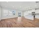Spacious living area featuring wood floors, a kitchen with stainless steel appliances, and many bright windows at 914 Montague Ave, Durham, NC 27703