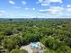 Aerial view showcasing the community pool surrounded by lush greenery and the city skyline in the distance at 924 Pebblebrook Dr, Raleigh, NC 27609