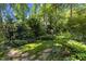 Landscaped backyard with mature trees and lush greenery, creating a peaceful retreat at 924 Pebblebrook Dr, Raleigh, NC 27609