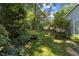 Lush backyard with green lawn and mature trees, creating a private oasis at 924 Pebblebrook Dr, Raleigh, NC 27609