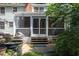 Backyard featuring a screened porch, brick patio, and beautifully landscaped gardens at 924 Pebblebrook Dr, Raleigh, NC 27609
