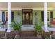 Welcoming front porch with elegant wood door, brick accents, and lush ferns creating a charming entrance at 924 Pebblebrook Dr, Raleigh, NC 27609