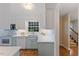 Modern kitchen with light countertops, stainless steel appliances, and access to the staircase at 924 Pebblebrook Dr, Raleigh, NC 27609