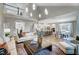 Open-concept living area with white sofas, high ceilings, wood floors, and adjoined kitchen at 9513 Wood River Dr, Zebulon, NC 27597