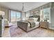 Beautiful main bedroom with a tufted headboard and large windows offering plenty of natural light at 9513 Wood River Dr, Zebulon, NC 27597